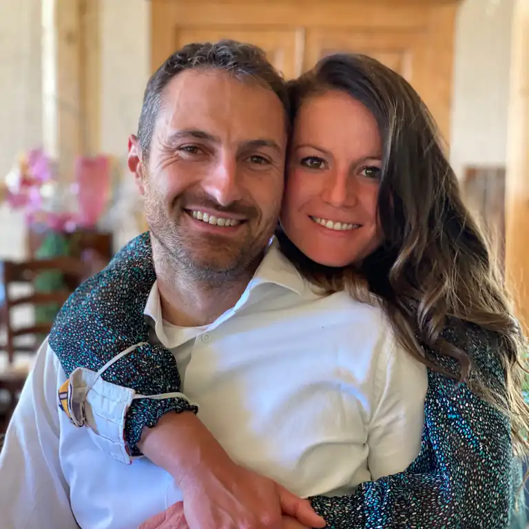 Foto di una coppia sorridente all'interno di un'abitazione con arredo in legno